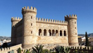 zamek colomares widok z zewnątrz na bajkową architekturę z wieżyczkami i łukami